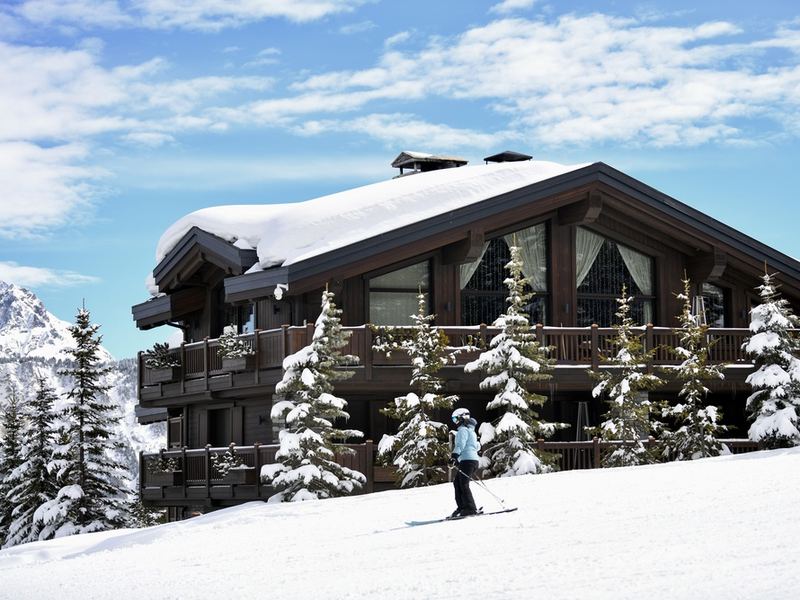 A skier passing a snow-covered chalet